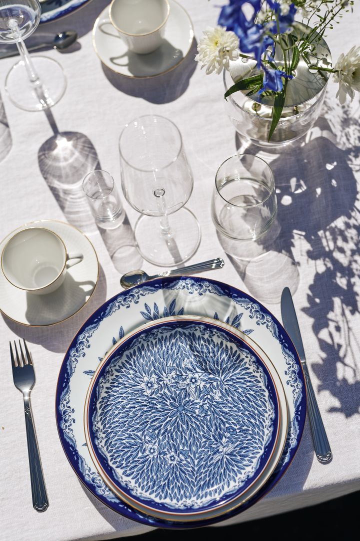 Skap vakre borddekkinger med stilig, blått og hvitt porselen fra Scandi Living - her på blå linduk, bestikk i rustfritt stål og enkle vinglass.