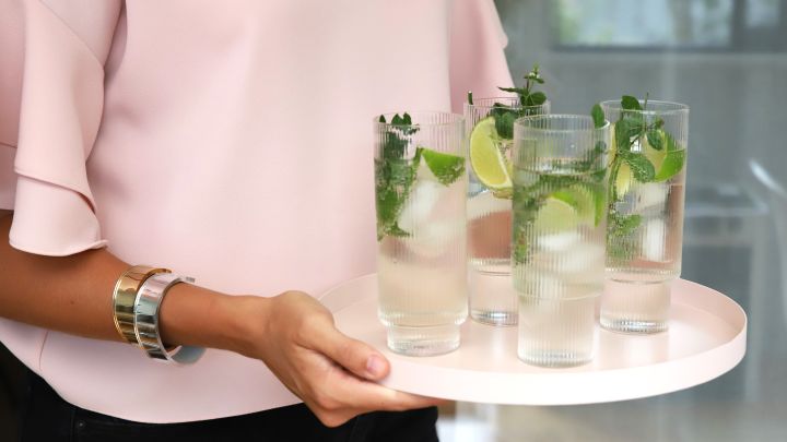 Gjestene tilbys en velkomstdrink på festen i long drink-glass fra Ferm Living servert på brett fra Cooee Design.