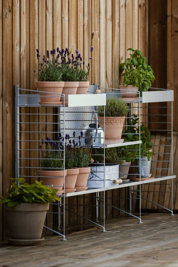 På @applauddens terrasse står en utendørshylle fra String, fylt med flere planter i Bergs Potters blomsterpotter fra Copenhagen-kolleksjonen.