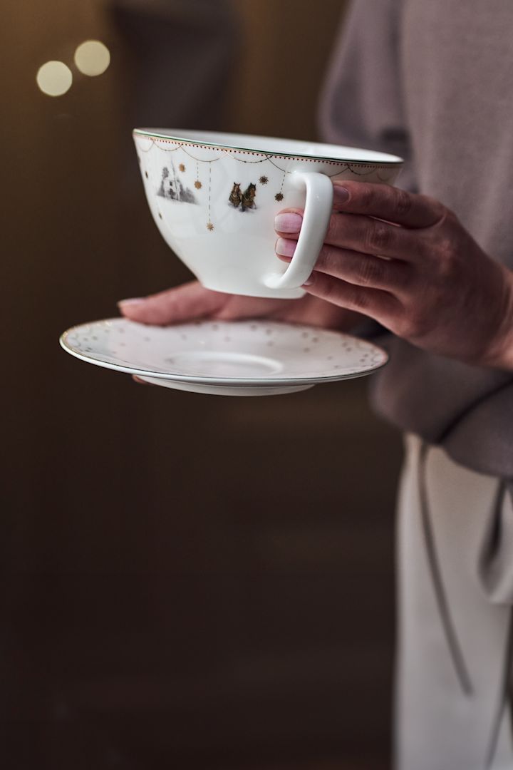 Her ser du en hånd som plasserer Julemorgon juleservise på en hylle.
