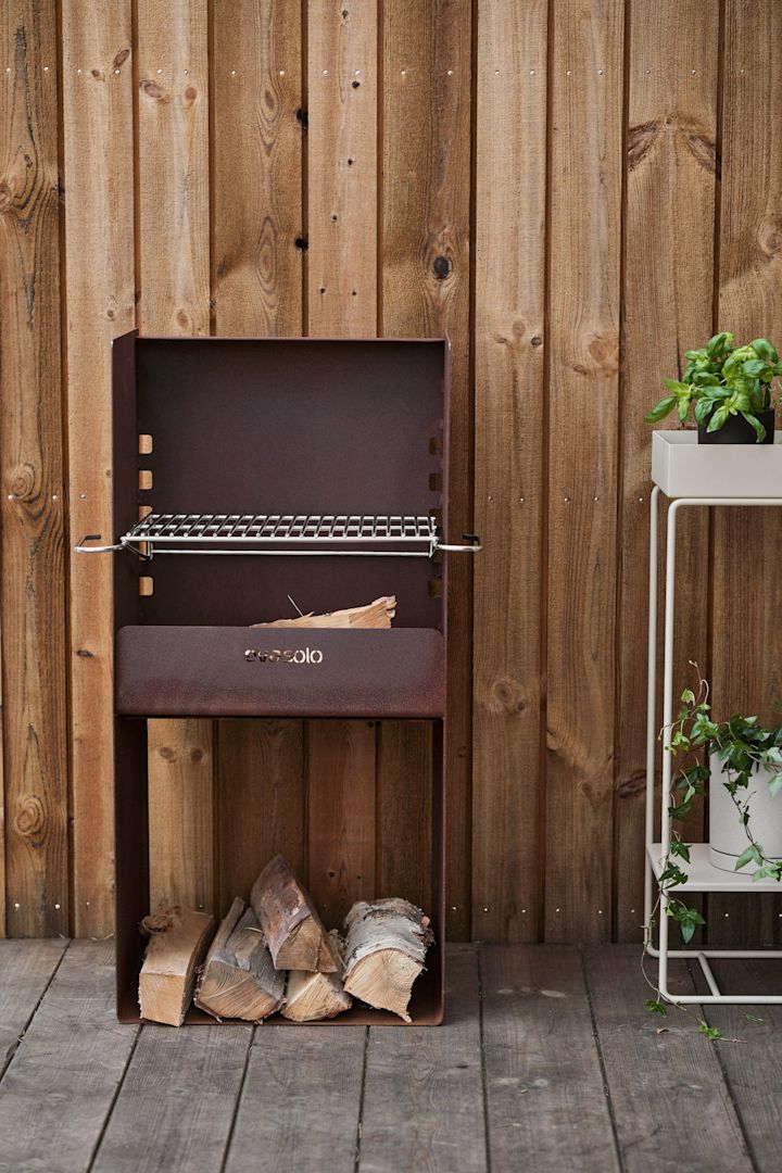 Den rustikke grillen FireSpot fra Eva Solo står på en terrasse av tre.