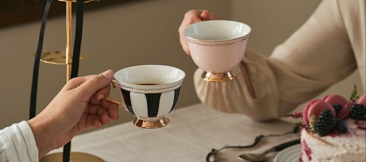 Feir Galentines med en tradisjonell afternoon tea med venninnene dine. Her ser du to venninner som skåler med te i klassisk formede tekopper fra Hilke.